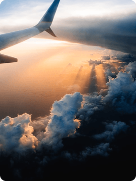 Airplane wing view above clouds